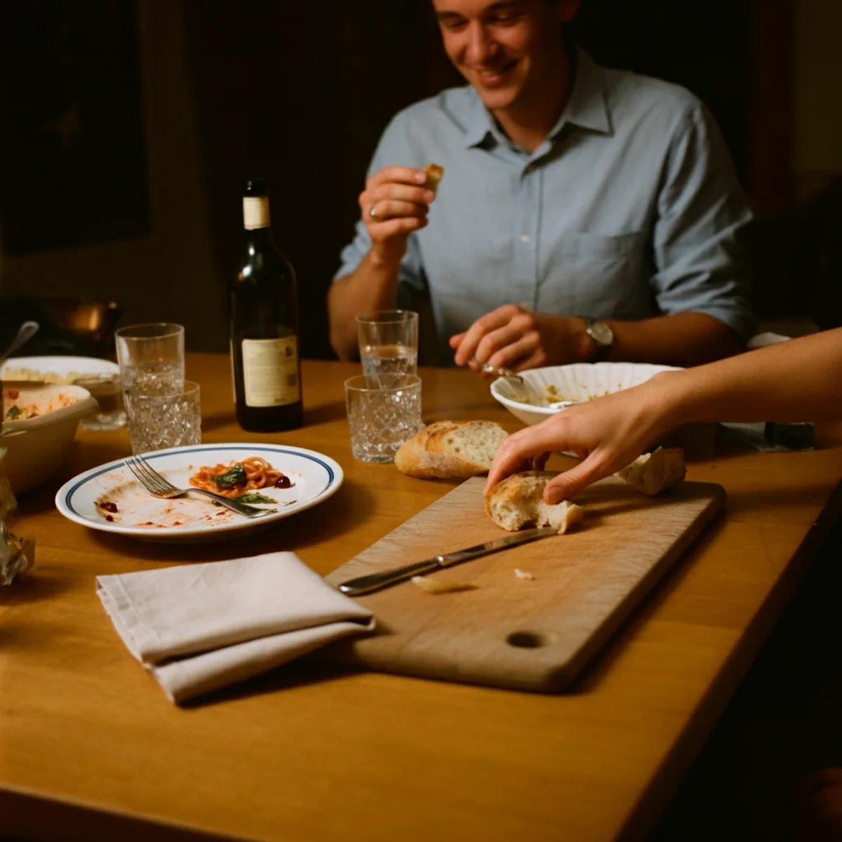 A dinner table with a hand holding a lollipop
