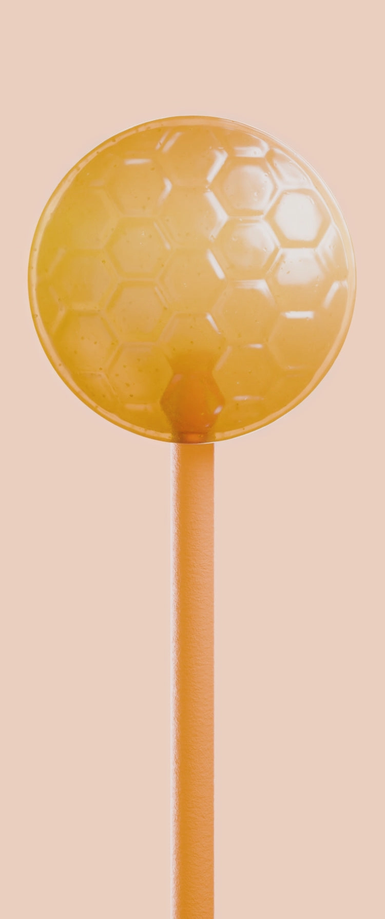 A single honey lollipop standing against a peach wall